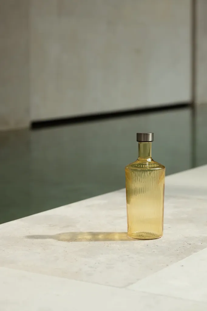 Premium_ribbed_glass_bottles_in_the_color_Cable_by_Paveau_bring_sophistication_warmth_and_refined_Belgian_design_to_every_dining_and_hospitality_set.webp